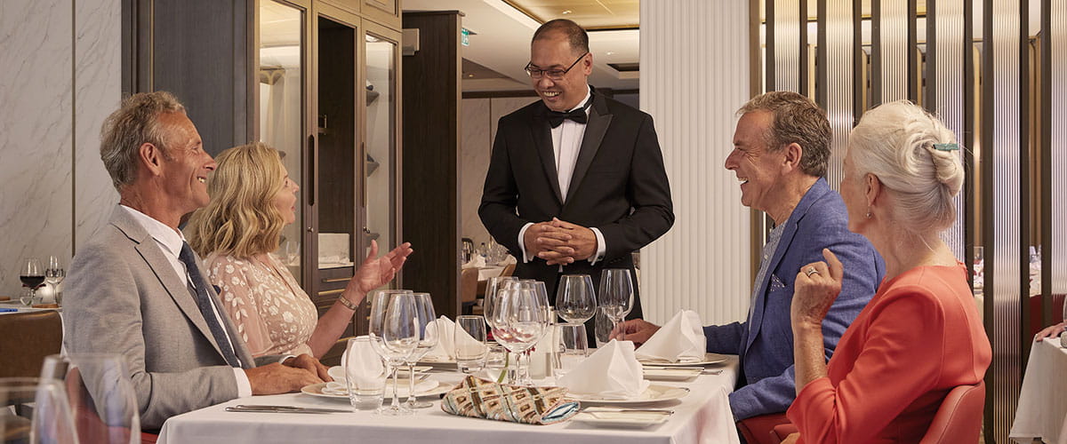 A group of friends dining together in the speciality Italian restaurant Amalfi on Spirit of Adventure